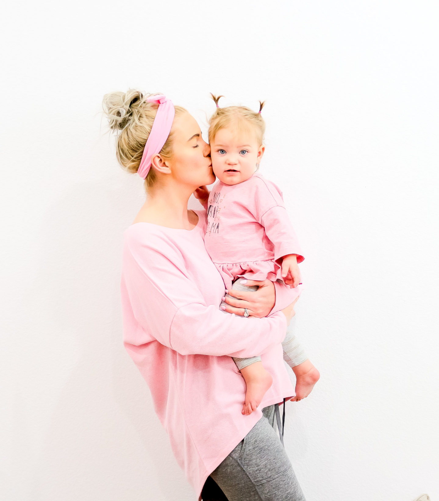 Mom holding daughter, wearing pink, white wall, SAHM